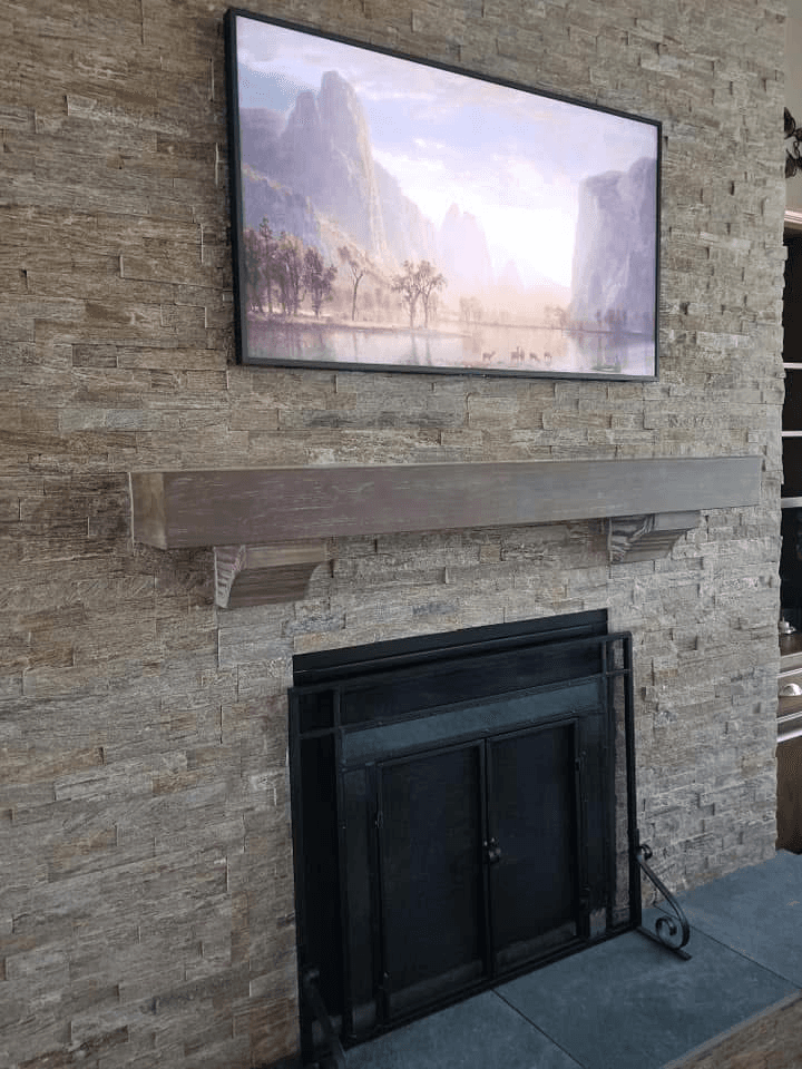 Samsung Frame TV displaying landscape art on stone accent wall