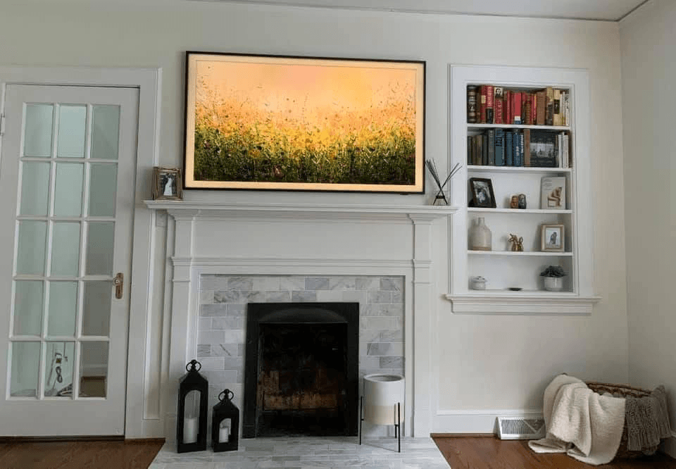 Samsung Frame TV showing wildflower painting above marble fireplace