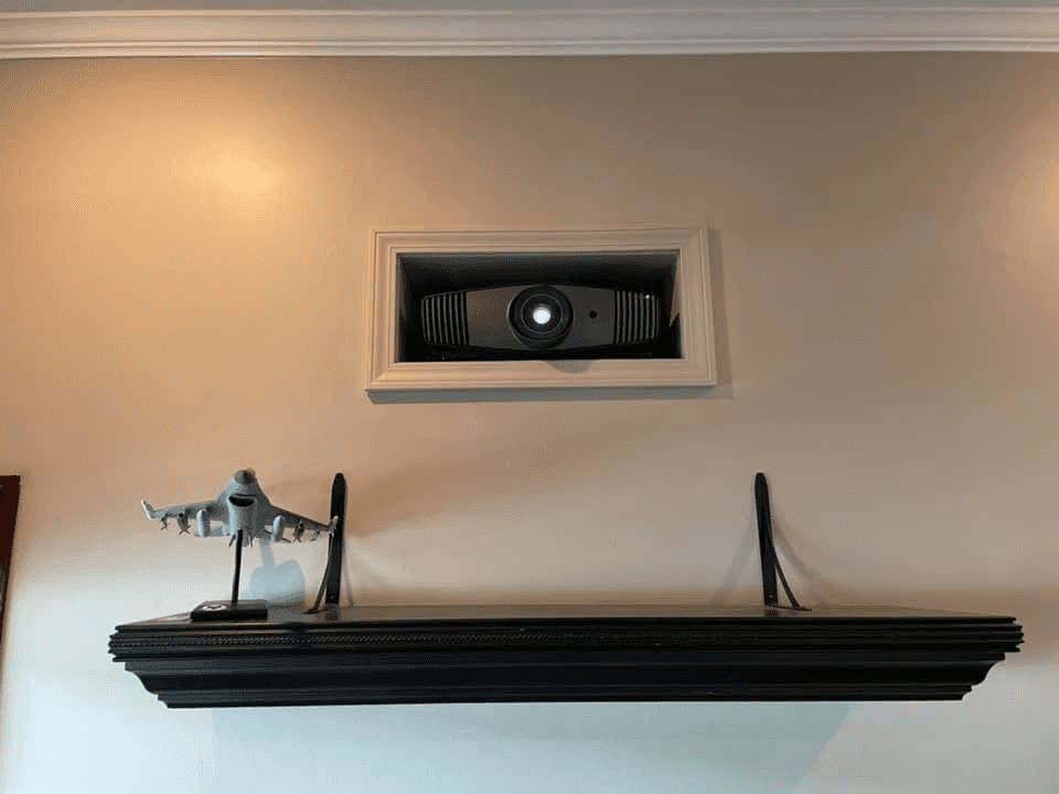 In-wall center channel speaker recessed above mantle shelf