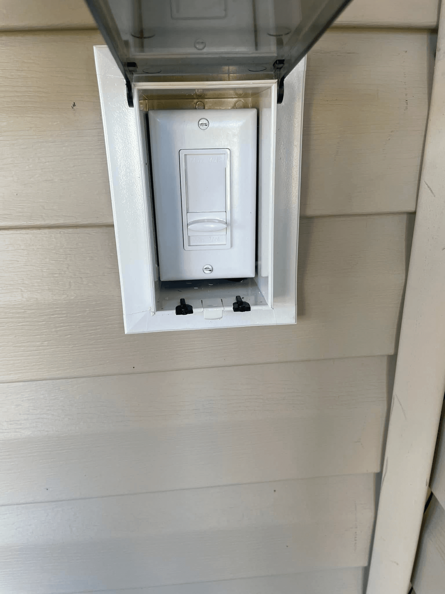 Weatherproof outdoor volume control switch installed on exterior siding