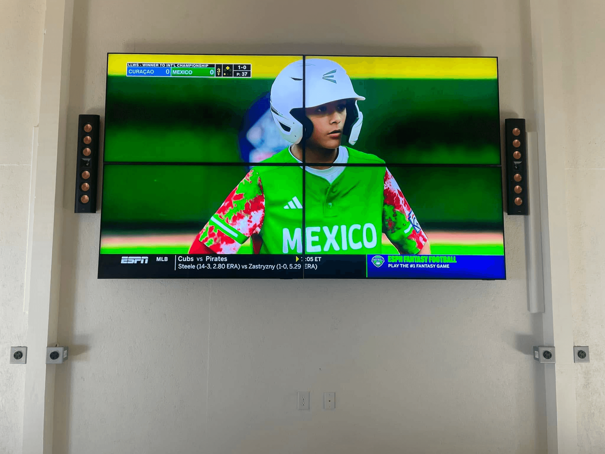 Four-panel video wall displaying ESPN baseball with tower speakers