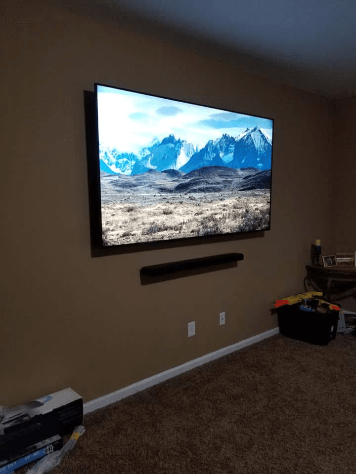 TV wall-mounted with soundbar on brown accent wall